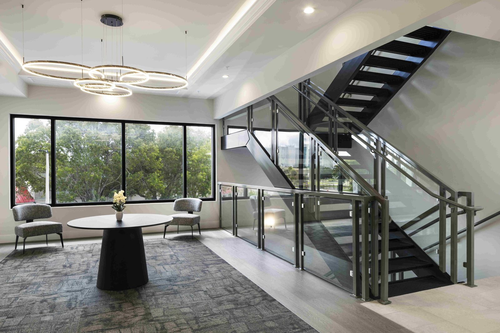 Light-filled landing with floor-to-ceiling windows and modern staircase
